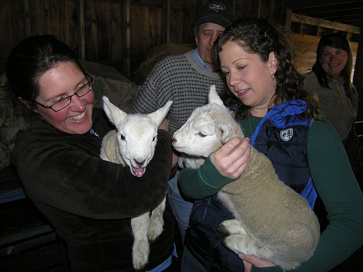 Two women holding lambs