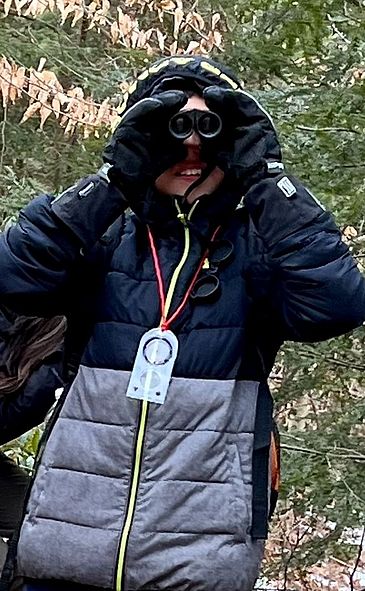 Child using binoculars in the woods